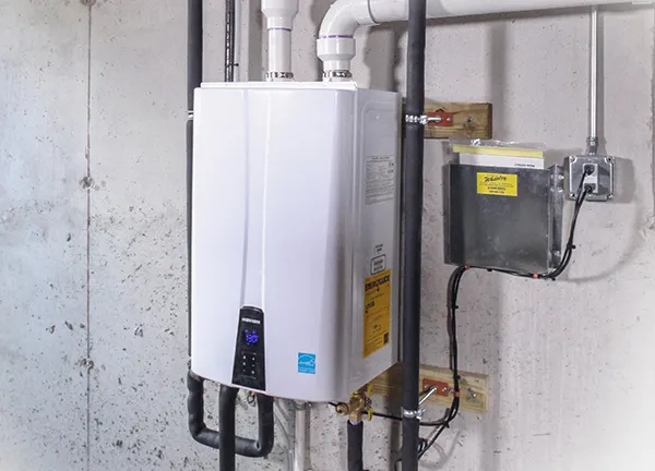 Energy-efficient tankless water heater installation on concrete wall in Hutchins TX.
